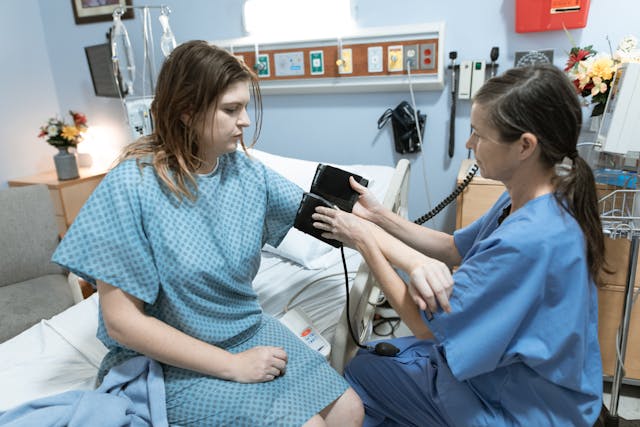 sestra měří tlak pacientce, platy zdravotníků